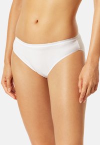 Vit bomullsbrief med en slät yta, låg midja och elastisk midjeband. Har en minimalistisk stil utan mönster eller detaljer.
