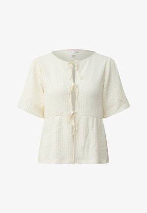 Kremowa teksturowana bluzka z krótkim rękawem, okrągłym dekoltem i trzema zawiązywanymi z przodu zapięciami, o luźnym, lekko rozkloszowanym kroju.