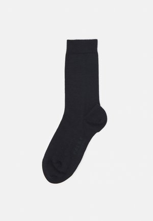 Svarta ankelsockor gjorda av ett mjukt och slätt tyg. Ribbad kant upptill, sömlös tådesign, med diskret branding på sidan.