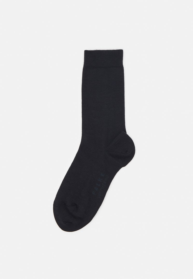 Chaussette noire à la cheville en tissu doux et lisse. Bord côtelé en haut, design de pointe sans couture, avec un branding discret sur le côté.