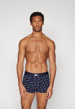 Boxer-briefs bleu marine avec un motif de logo, taille élastique et texture douce. Présente un design ajusté et un confort optimal.