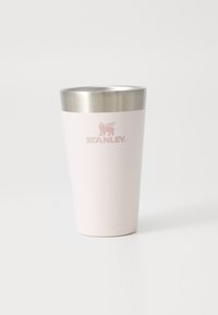 Stainless steel tumbler with a light pink matte finish and a silver metal lid. "STANLEY" logo embossed in pink on the front.