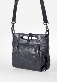 Marineblaue Lederschultertasche mit weicher Textur, einer Vorderreißverschlusstasche und einem verstellbaren Schultergurt, ausgestattet mit einem Druckknopfverschluss und Obergriffen.