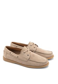 Mocassini beige in suede con design moccasin, allacciatura frontale, suola in gomma e dettagli di cucitura laterale. Texture liscia con una vestibilità classica.