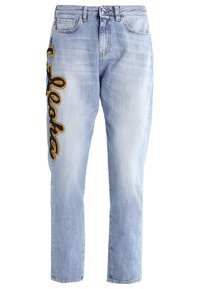 Jeans de mezclilla azul claro con un ajuste relajado, que presentan texto bordado en amarillo oscuro en el muslo izquierdo. Cinco bolsillos y un lazo para cinturón.