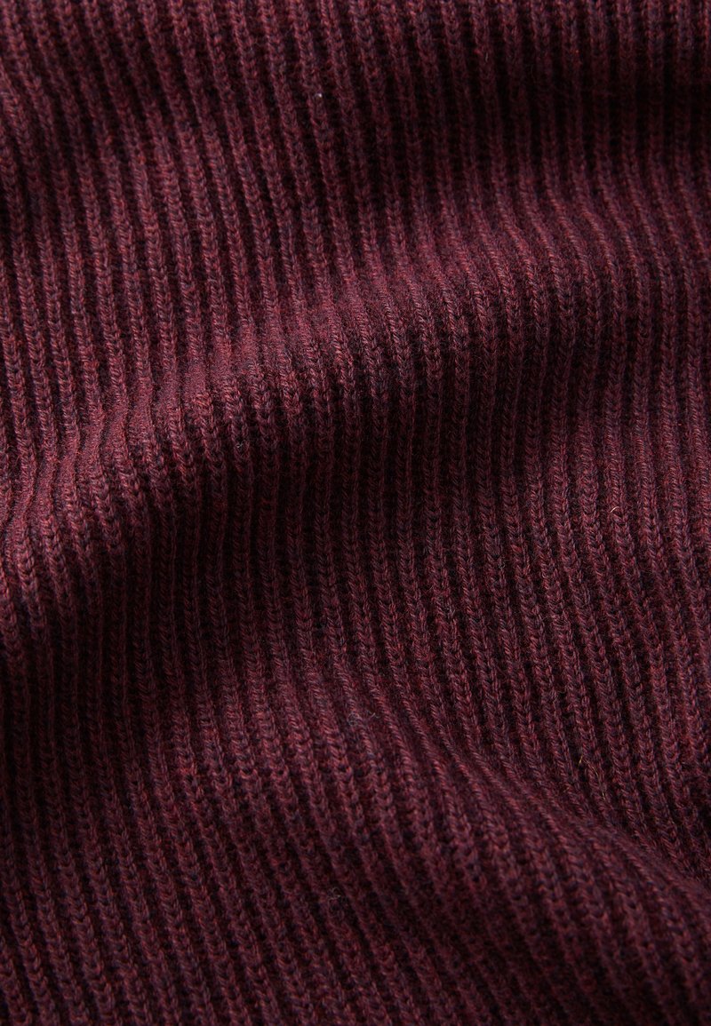 Burgundy knit fabric with vertical ribbing pattern, soft texture, and slight sheen, folded to showcase depth and dimension.