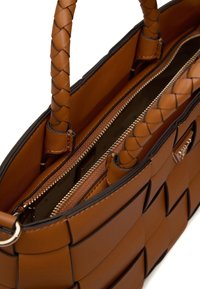 Borsa a mano in pelle marrone con design intrecciato. Presenta due scomparti con zip e manici intrecciati. Texture liscia con accenti di metallo.