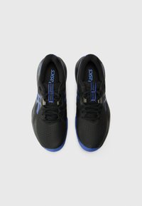 Baskets de sport noires avec des accents bleus, tige texturée, surface perforée et lacets noirs. Présente un logo sur la languette.