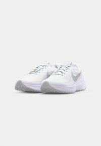 White athletic shoes with a textured mesh upper and gray accents, featuring a flexible rubber sole and lace-up closure.