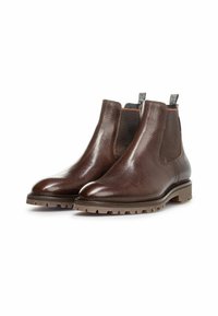 Un par de botas Chelsea de cuero marrón texturizado con paneles laterales elásticos y suelas con tacos sobre un fondo blanco.