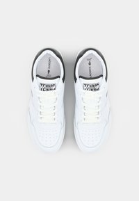 Adidași din piele albă cu accente negre, vârf perforat și șireturi plate albe. Branding vizibil pe limbă și pe talpă. Design clasic de tip low-top.
