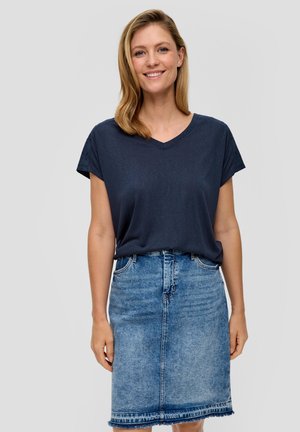 T-shirt V en marine à manches courtes associé à une jupe en denim bleu clair avec un ourlet brut et des poches avant.