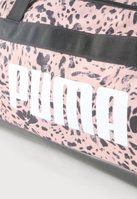 Τσαντάκι duffel με ροζ και μαύρο λεοπάρ μοτίβο, με μαύρα λουριά και μεγάλο λευκό λογότυπο PUMA στο πλάι.