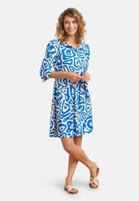 Blau-weißes Kleid mit abstraktem Muster, Knopfverschluss vorne, drei Viertelärmel und einem gebundenen Gürtel in der Taille.