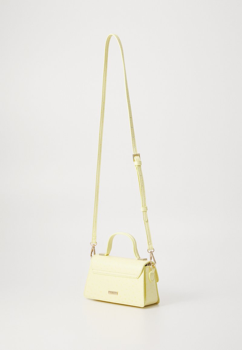 Sac à main en simili cuir jaune avec un design structuré, une poignée supérieure et une bandoulière ajustable. Présente une texture lisse et des motifs subtils.