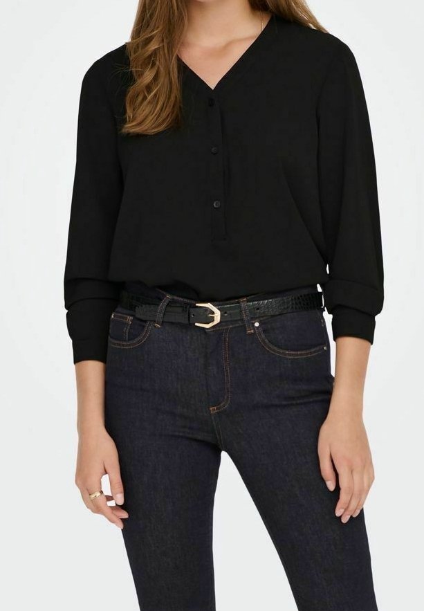Blusa nera a maniche lunghe con scollo a V e chiusura a bottoni, abbinata a jeans in denim scuro e una cintura nera texturizzata.