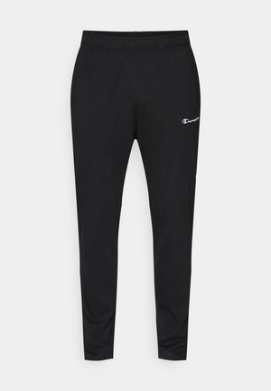 Pantalons de sport noirs avec une taille élastique, une coupe fuselée et un petit logo blanc sur la cuisse gauche. Tissu lisse.