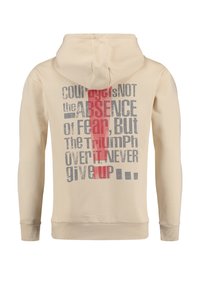 Sudadera beige con bolsillo canguro y capucha forrada. Presenta un texto en negrita gris y rojo en la parte trasera. Tejido suave, puños y dobladillo acanalados.