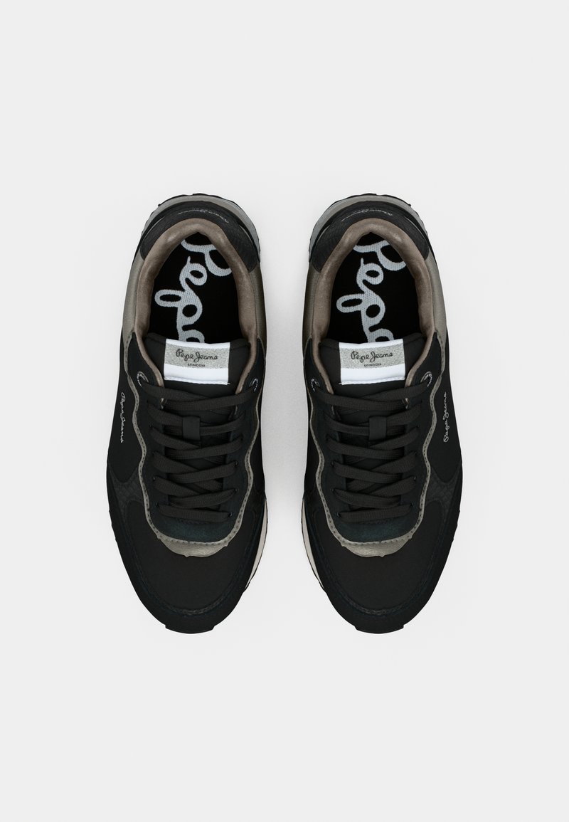 Schwarze sportliche Sneakers mit strukturierten Oberflächen, grauen Akzenten und auffälligen Schnürsenkeln. Das Innere verfügt über kontrastierende Logodetails.