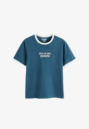Kék rövid ujjú póló fehér gallérral és ujjvégekkel, japán szöveggel és a "Yokohama" felirattal a mellkason.