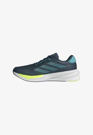 Dunkelblaue Sportschuhe mit Obermaterial aus Mesh, weißer Sohle und neon-gelben Akzenten. Verfügt über das Logo mit drei Streifen und einen gepolsterten Kragen. Aerodynamische Form.