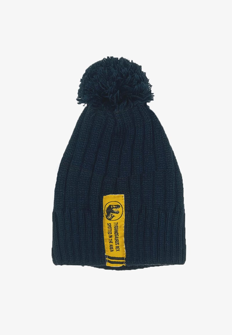 Gorro de punto azul oscuro con un pom-pom en la parte superior y una etiqueta amarilla con un gráfico y texto. La textura es acanalada y suave.