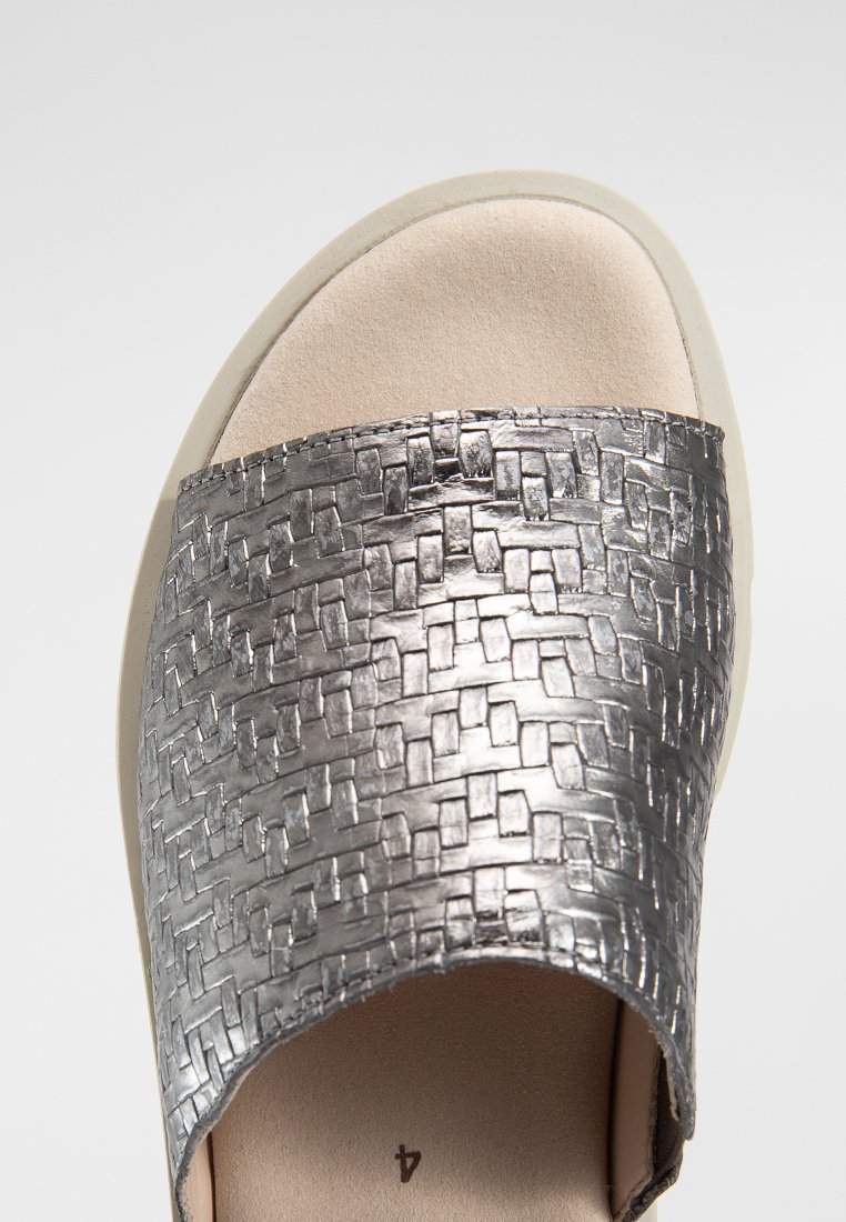 Metalen zilveren slide sandaal met geweven textuur over de band, lichtbruine gevoerde zool en een neutraal gekleurde onderzool.