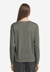 Grüner Pullover mit langen Ärmeln, weitem Ausschnitt und geripptem Saum, von hinten angezeigt. Das Material wirkt glatt und leicht.