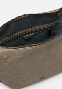 Szara skórzana torba o gładkiej fakturze, z zamknięciem na zamek błyskawiczny i niebieską tkaniną wewnątrz z małą kieszonką na zamek.