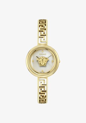 Zlata ročna ura Versace z okroglo belo številčnico, emblemom glave Meduze na sredini, zlato geometrijsko vzorčastimi povezavami zapestnice in minimalističnimi oznakami ur.
