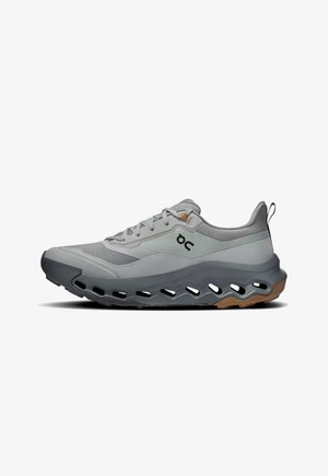 Gray athletic shoe features mesh and synthetic upper, lightweight design, distinctive cutouts in the sole, and a rubber outsole with traction.