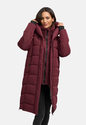 Bordeaux pufferjack met een hoge kraag, ritssluiting aan de voorkant en een oversized capuchon. Bevat gequiltte delen en zijzakken.