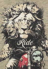 Leone con criniera fluente che guida una motocicletta rossa, indossando una maglietta nera con la scritta "Ride Like a King" sul davanti.