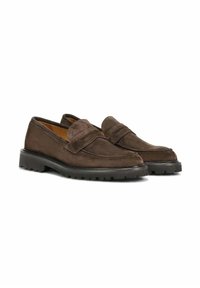 Mocassins en suède brun avec un design de mocassin, des détails cousus et une semelle en caoutchouc épaisse pour l'adhérence. Présentent une finition lisse et un style à enfiler.