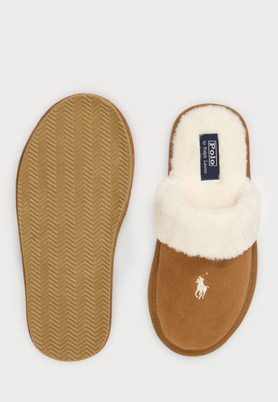 Rudi od suede, su šviesiai balta vilna, plokščiu guminiu padu ir Polo Ralph Lauren logotipu ant viršaus bei viduje.