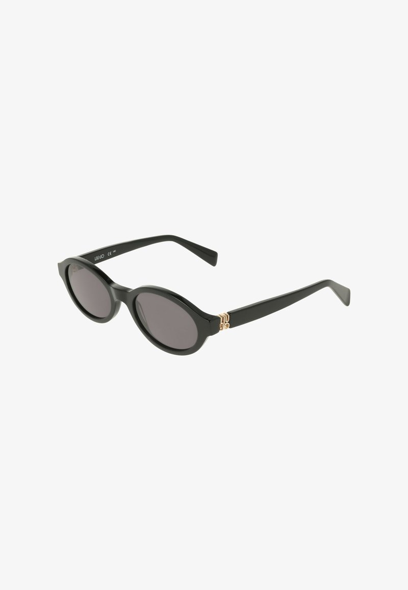 Lunettes de soleil noires avec une monture arrondie, des verres foncés et des accents en métal doré. Matériau en plastique lisse ; design épuré et minimaliste.
