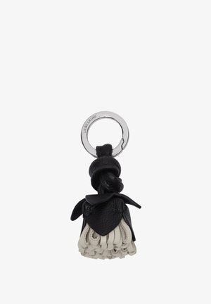 Silberner Schlüsselanhänger mit eingraviertem Markennamen, an dem ein schwarzer Lederknoten und eine cremefarbene Lederquaste in Blumenform befestigt sind.