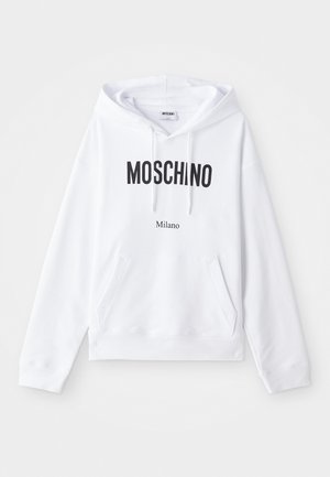 Hoodie blanc avec une poche kangourou, un cordon de serrage ajustable et un grand texte noir "MOSCHINO" et "Milano" imprimé sur le devant.