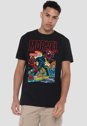 Man wearing black Marvel t-shirt featuring Spider-Man and Tombstone comic characters in action poses with bright comic-style colors.