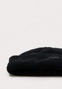Mustreeritud musta lõngaga beanie. Kanga tekstuur on pehme ja paindlik, omades ülespoole keeratud ääret ja diskreetset brändingu detaili.