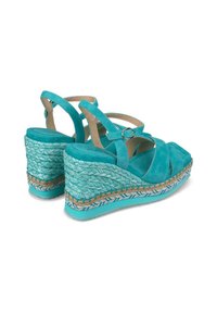 Turquoise suède wedge sandalen met kruisbanden, textuur van gevlochten raffia-details en een platte geweven jute accent rond de zool.
