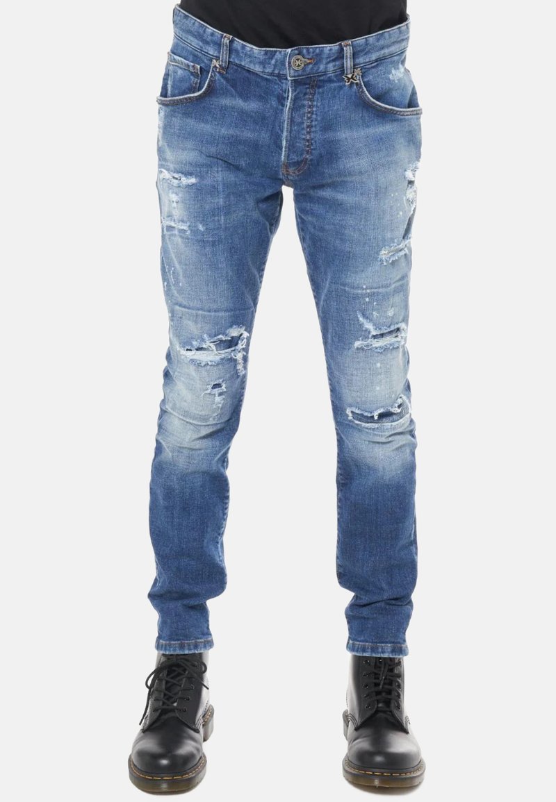 Jeans in denim blu con una vestibilità slim, caratterizzati da aree scolorite e toppe sfilacciate. Completati con cinque tasche e chiusura con bottone.