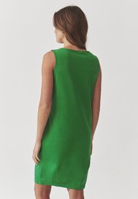 Green sleeveless dress with a relaxed fit, made of soft material, featuring a round neckline and a straight hemline.