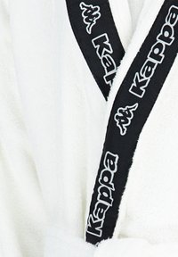 Weißer Bademantel aus weichem Frottiergewebe, mit einem schwarzen Gürtel und weißen "Kappa"-Markierungen sowie Logoakzenten an den Rändern.