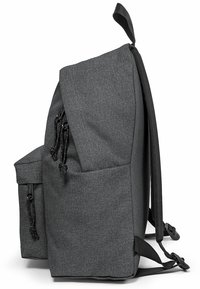 Mochila de tela gris con forma estructurada, correas ajustables, bolsillo lateral con cierre de cordón y base plana para mayor estabilidad.