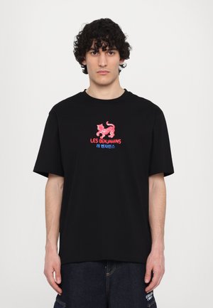 Black cotton t-shirt features a red and blue graphic design with a stylized lion and text reading "LES BENJAMINS" in bold lettering.