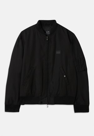 Črna bomber jakna z zadrgo spredaj, rebrastim ovratnikom in manšeti, dvema stranskima žepoma z zaponkami ter našitkom na levem rokavu.