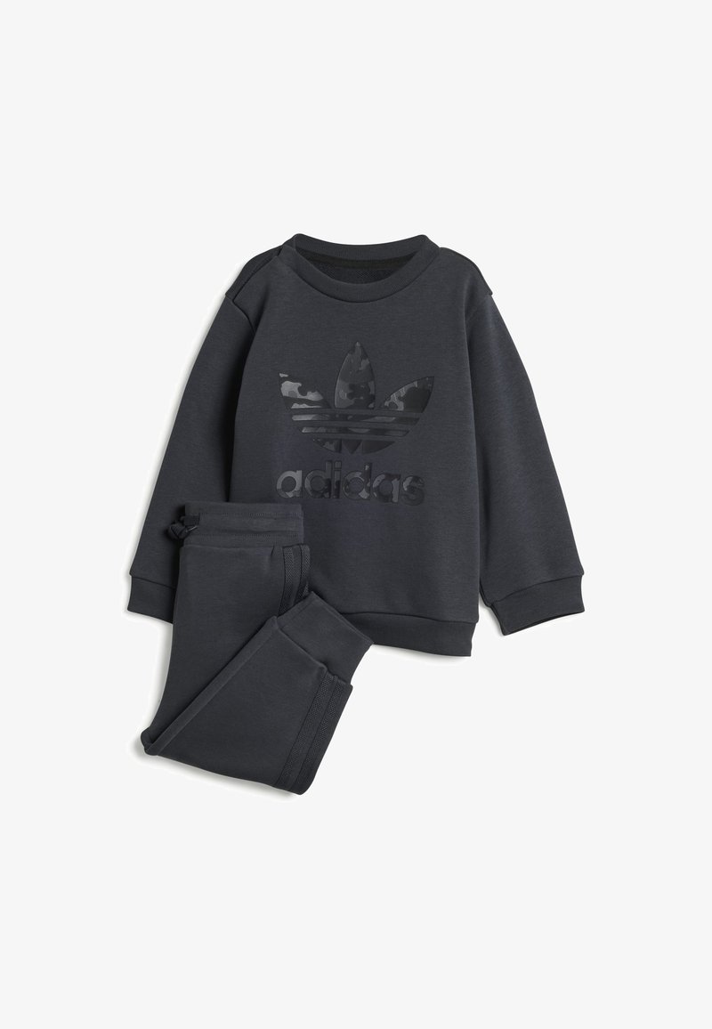Conjunto atlético de color gris oscuro que incluye una sudadera con un logo de adidas negro mate y pantalones con cintura elástica y franjas laterales. Tejido suave.