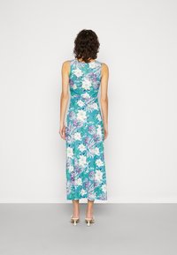Vestido maxi floral em verde-água com padrões de flores brancas e roxas, design sem mangas, tecido suave e um corte relaxado.