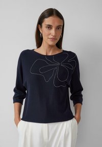 Pull en maille bleu marine à manches trois-quarts et motif floral souligné en fil argenté, avec un large col bateau et une coupe décontractée.
